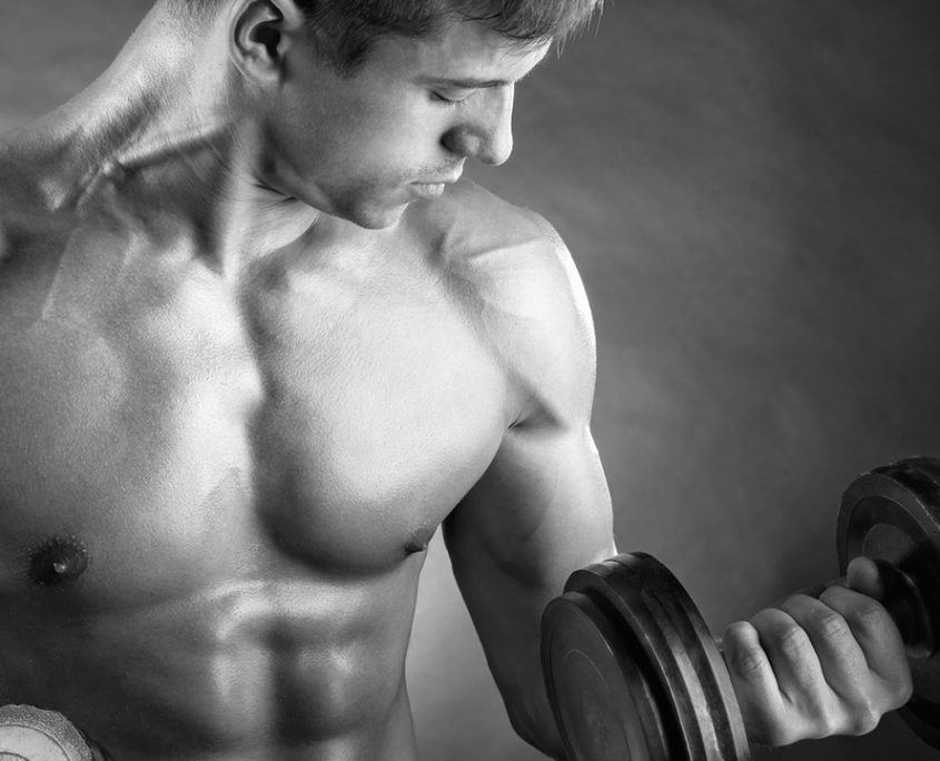 A man lifting dumbbells and flexing his biceps.
